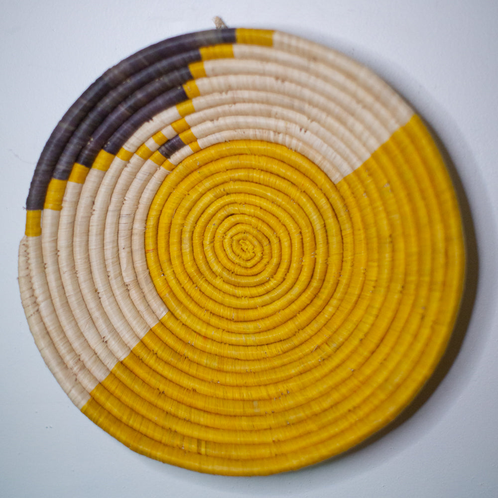 JustOne's yellow wall basket with grey and tan design, handwoven in Uganda