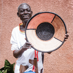 JustOne's pink and tan wall basket with navy outline, handwoven in Uganda