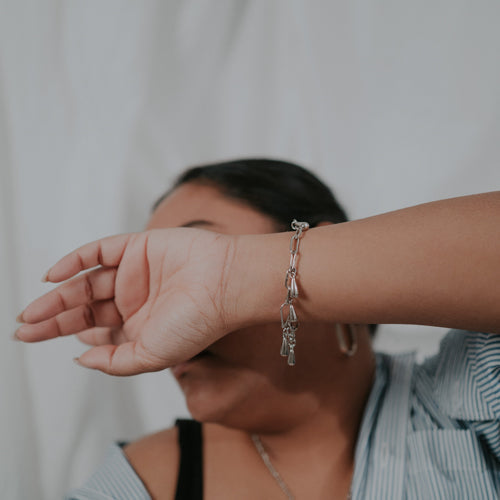 JustOne's silver chainlink bracelet with teardrop charms dangling off, handcrafted in Kenya