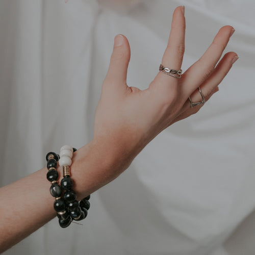 JustOne's bracelet with black and white beads made from ethically sourced bone and brass rings mixed in, handmade in Kenya