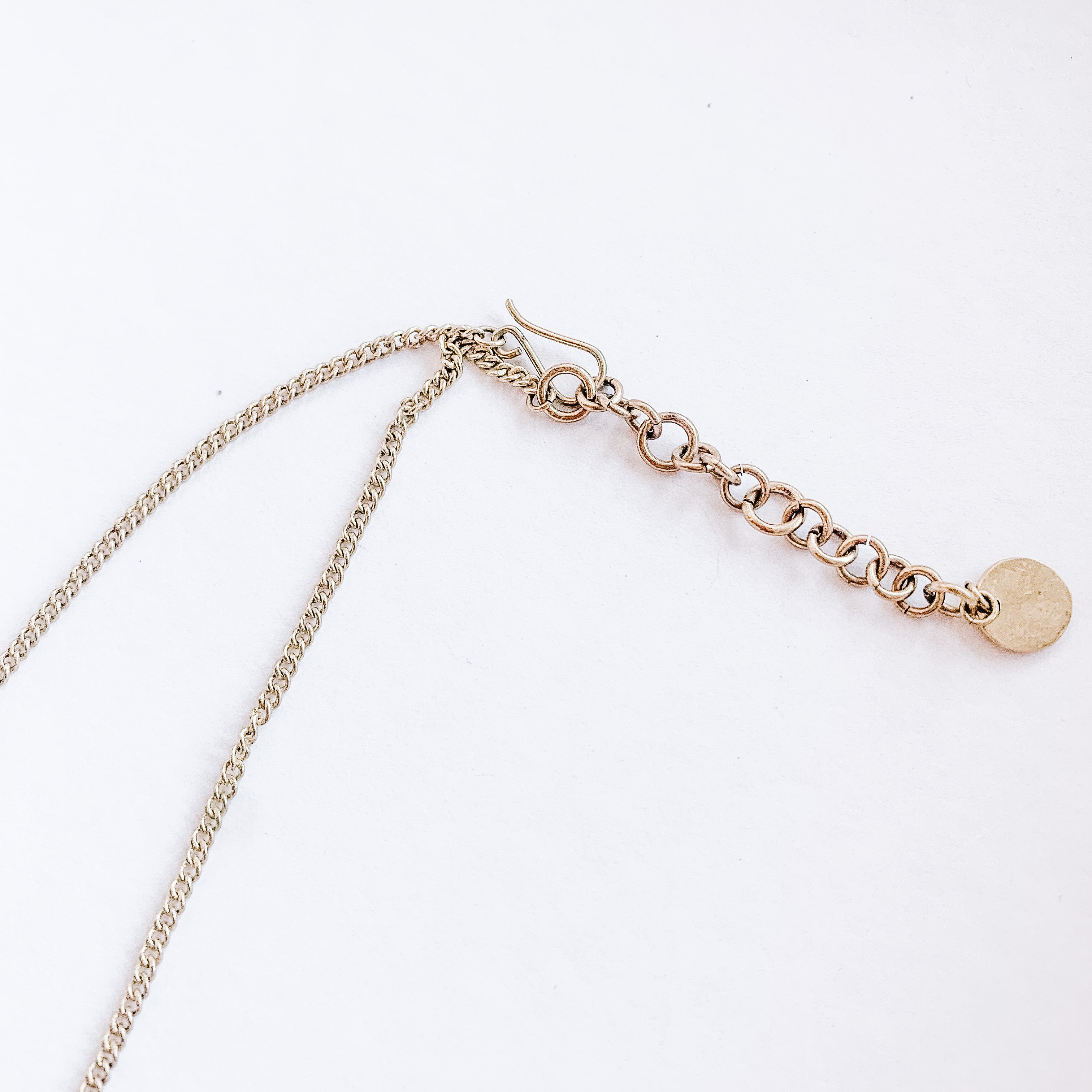 JustOne's brass necklace with small circular medallions dangling off the chain, handcrafted in Kenya