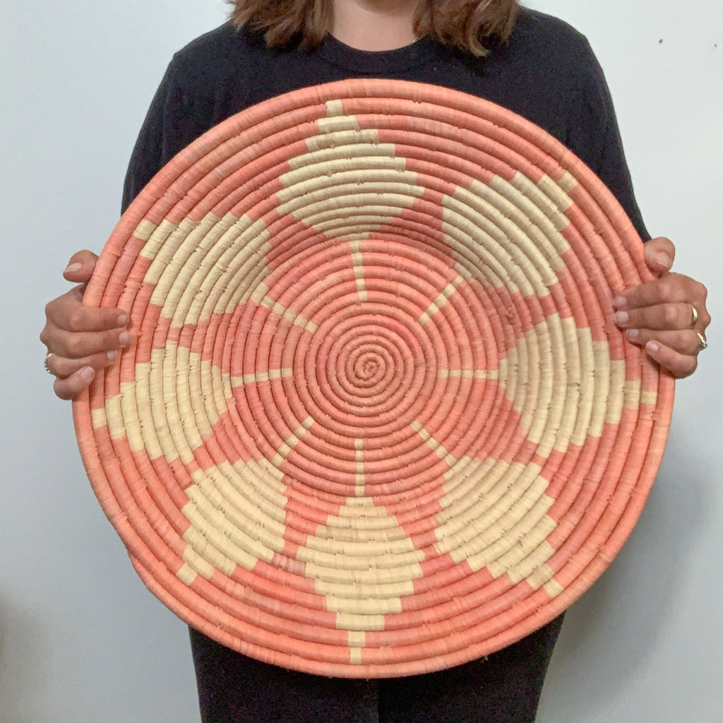 JustOne's 20 inch pink wall basket with tan design, handwoven in Uganda